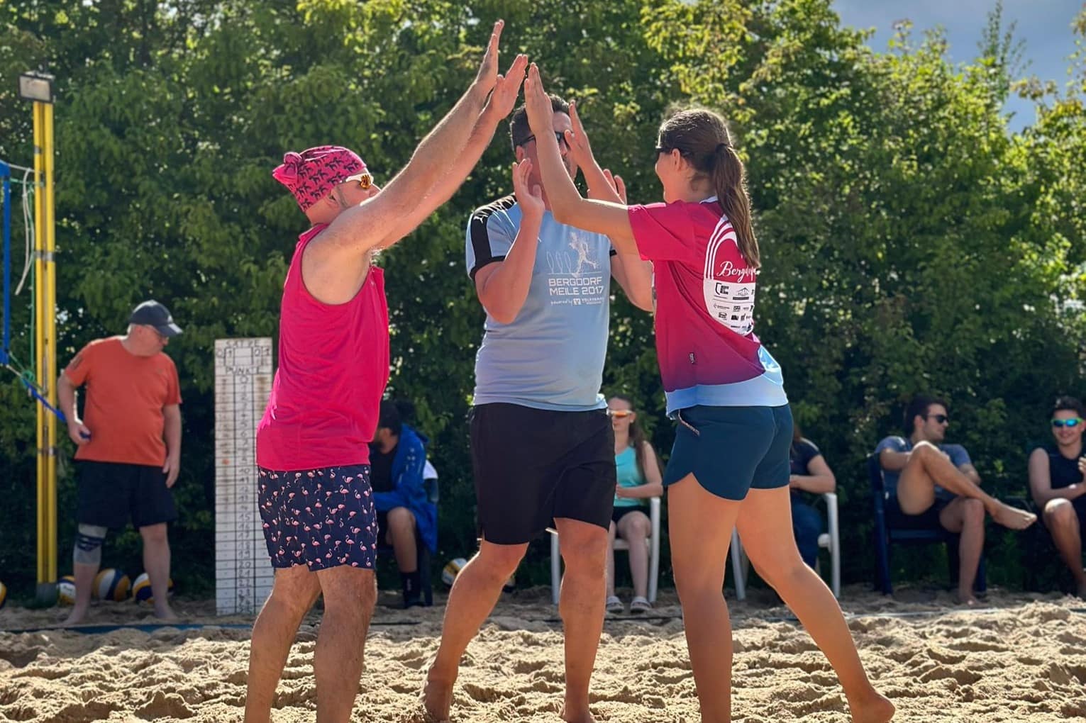 Drei Spieler*innen klatschen sich ab beim Beach cup 2024 in Grünwettersbach Drei Spieler*innen klatschen sich ab beim Beach cup 2024 in Grünwettersbach
